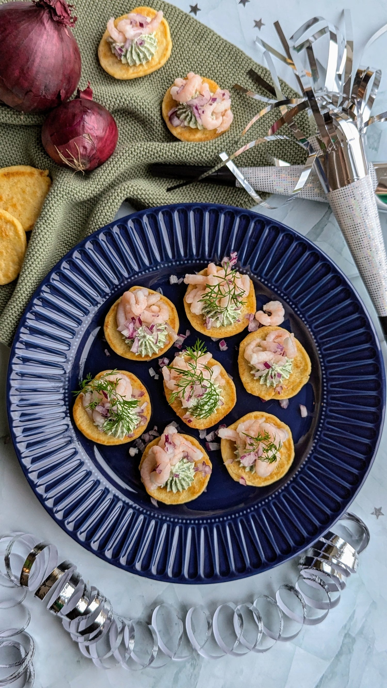 Blinis med kikærter, rejer, smøreost og rødløg