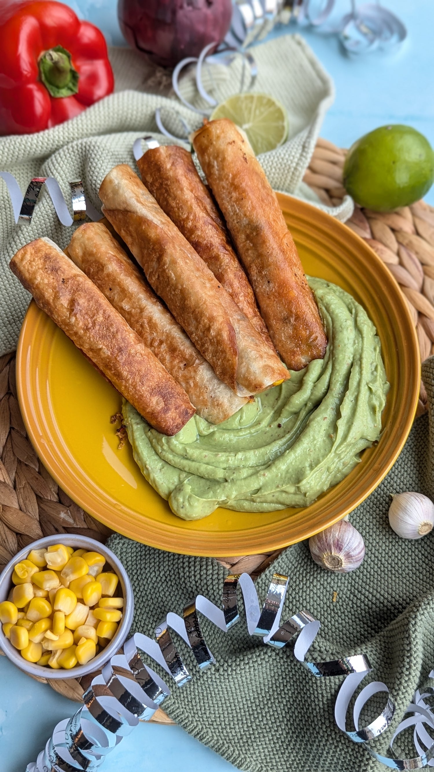 Taquitos med sorte bønner og cheddar fyld serveret med en cremet guacamole